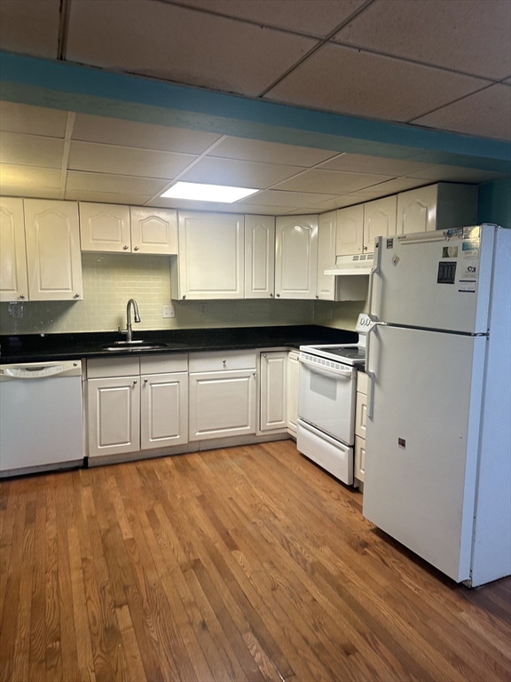 56 Howe Avenue, Unit 1 Shrewsbury, MA 01545 - Photo 3 of 10 a kitchen with granite countertop a refrigerator a sink and wooden cabinets