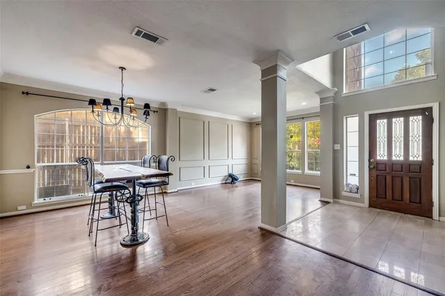 an open kitchen with granite countertop wooden floor dining table and chairs