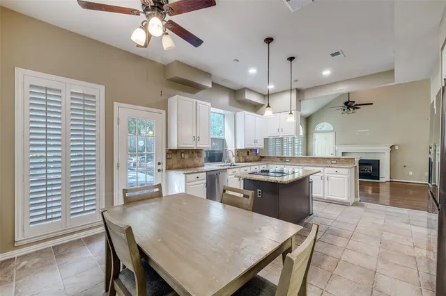 a kitchen with a dining table chairs stainless steel appliances and cabinets