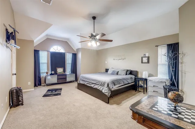 a bedroom with a bed a chandelier and a couch