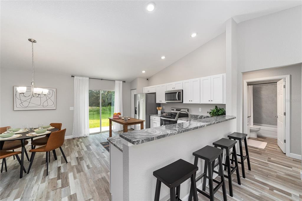 8571 Southwest 131st Place Ocala, FL 34473 - Photo 14 of 32 a kitchen with counter space dining table and chairs