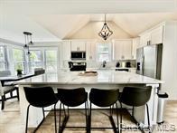 275 Sound Road Greenport, NY 11944 - Photo 16 of 28 Kitchen with pendant lighting, white cabinetry, plenty of natural light, light countertops, and lofted ceiling