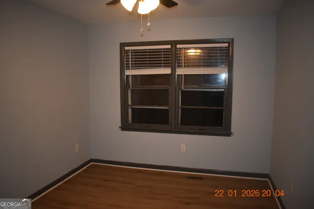 an empty room with wooden floor closet and chandelier fan
