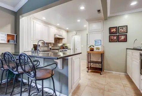 a kitchen with a dining table chairs refrigerator and cabinets