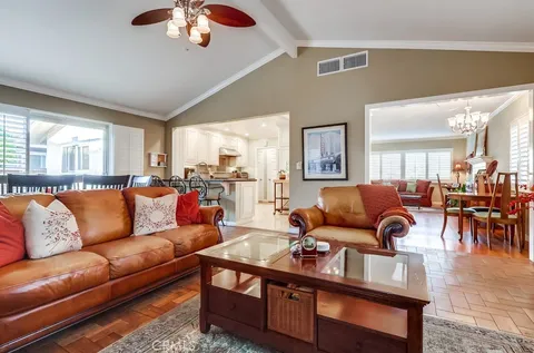 a living room with furniture kitchen view and a large window