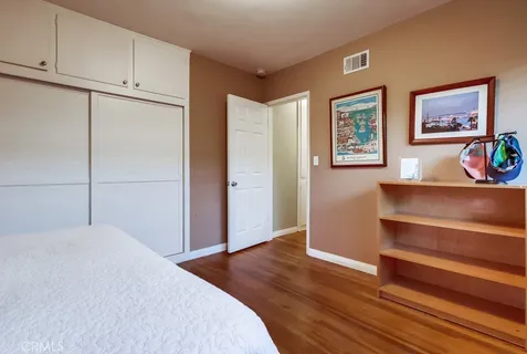 a bedroom with a bed and a painting on the wall