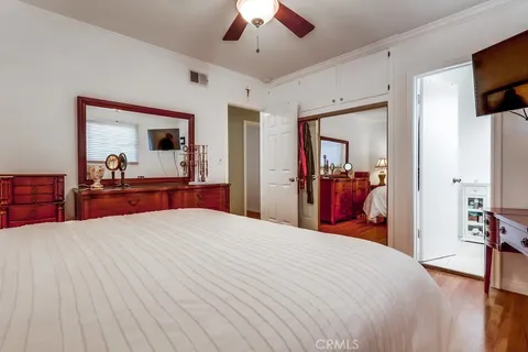 a bedroom with a large bed and a flat tv screen on dresser
