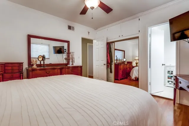 a bedroom with a large bed and a flat tv screen on dresser