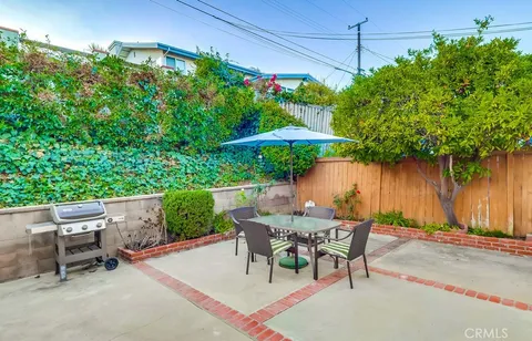 a patio with a table and chairs under an umbrella