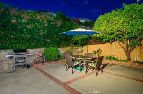 a view of backyard with outdoor seating and trees