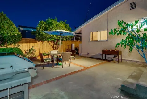 a view of a patio with a table and chairs under an umbrella
