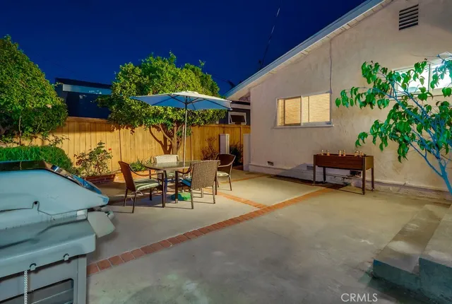 a view of a patio with a table and chairs under an umbrella