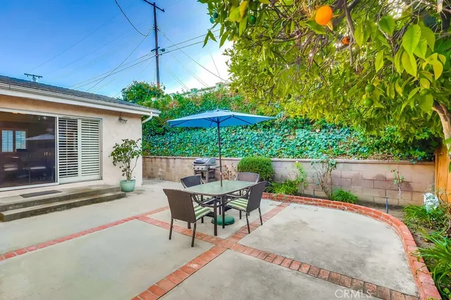 a view of a patio with table and chairs under an umbrella