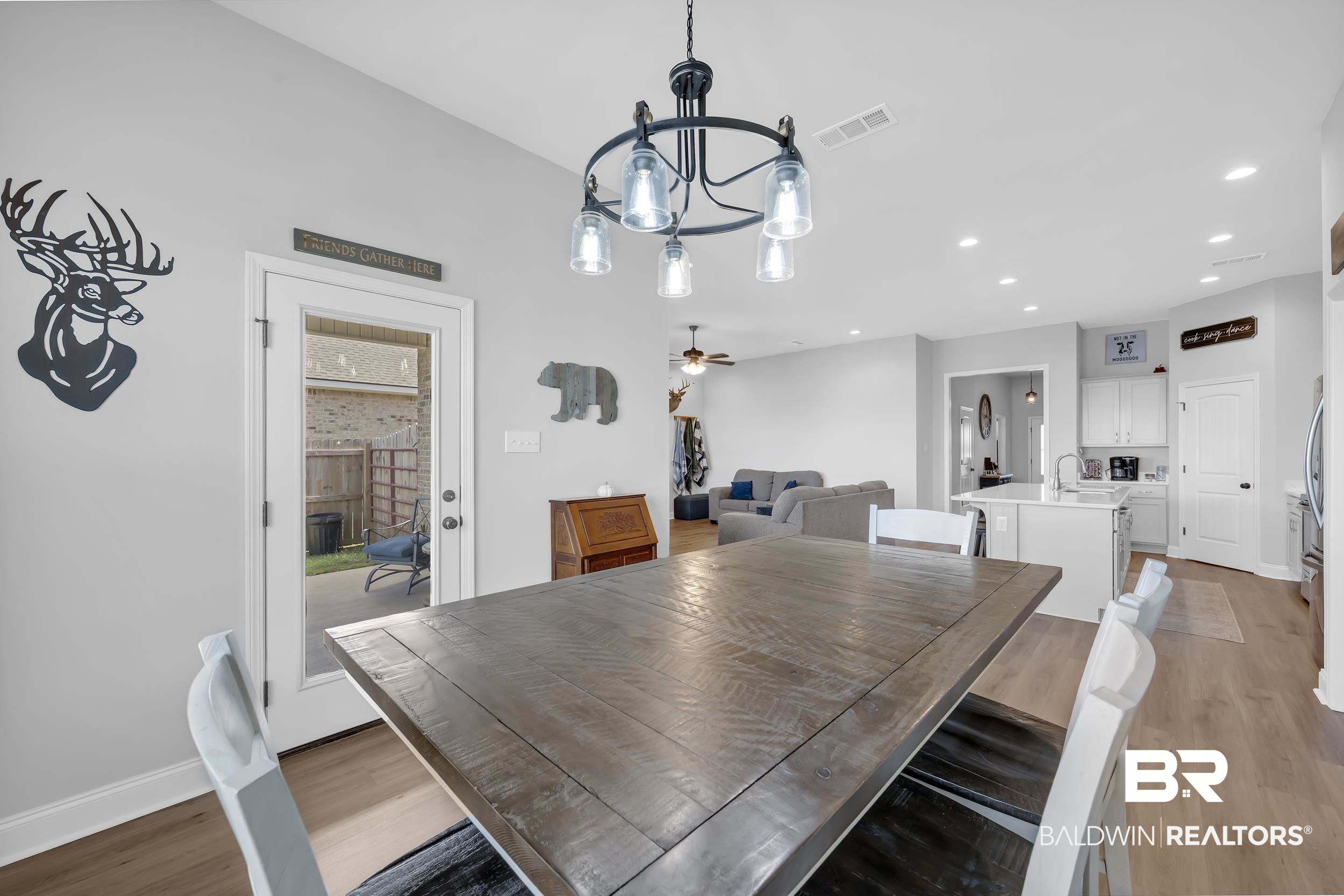 1176 Stella Road Foley, AL 36535 - Photo 15 of 40 Dining space with light wood finished floors, a chandelier, and a ceiling fan