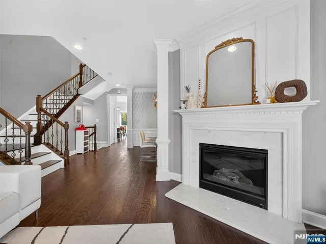 a living room with wooden floor and a fireplace