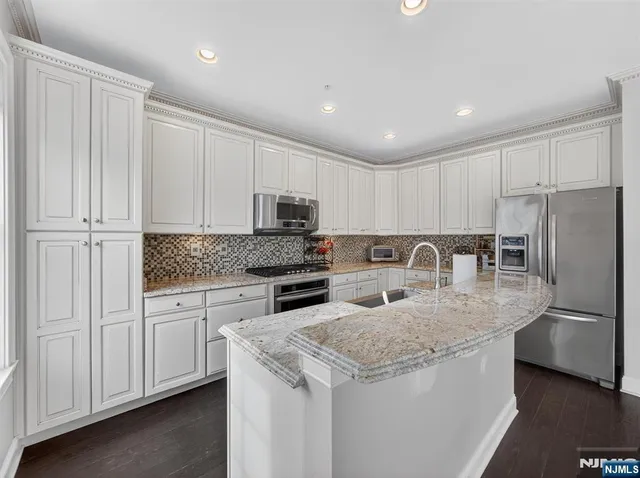 a kitchen with stainless steel appliances granite countertop a refrigerator sink and cabinets