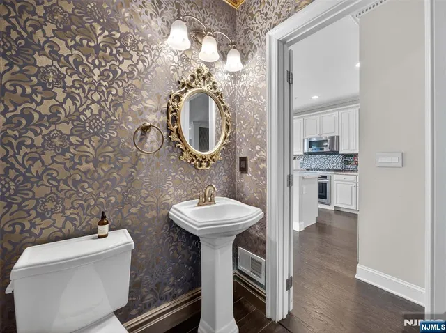 a bathroom with a sink a toilet and a mirror