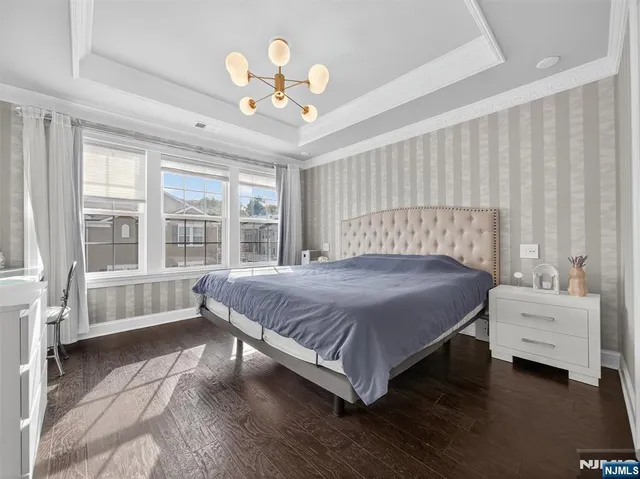 a spacious bedroom with a bed and a chandelier