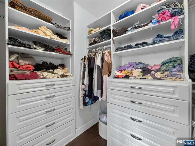 a view of walk in closet with clothes and shoes