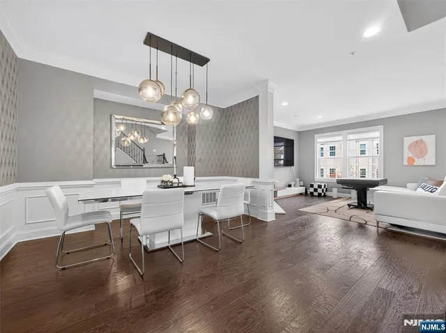 a living room with couches and kitchen view with wooden floor