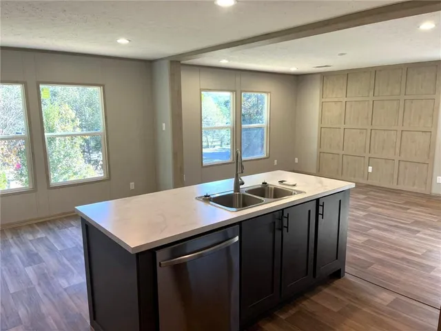 a kitchen with a sink and wooden floor