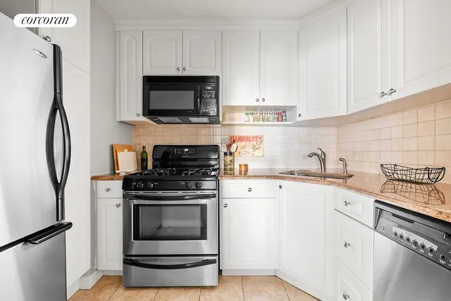 a kitchen with white cabinets stainless steel appliances and sink