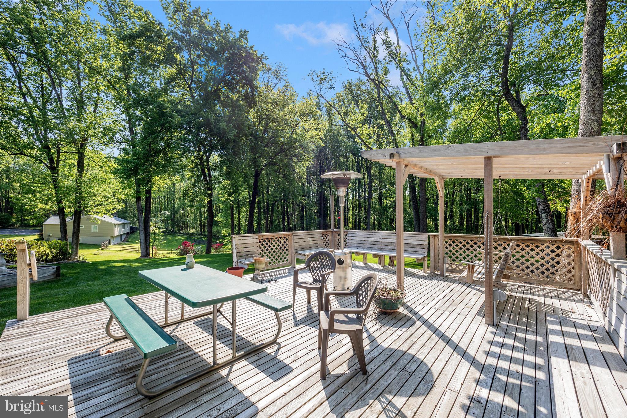 13949 Brighton Dam Road Clarksville, MD 21029 - Photo 22 of 27 a view of a patio with a dining table and chairs with wooden floor and fence