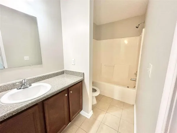 a bathroom with a granite countertop sink a toilet and shower