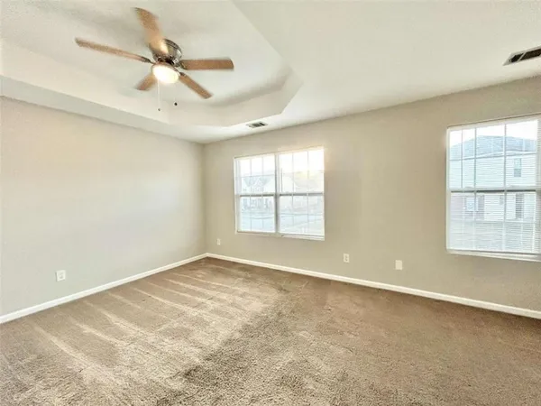 an empty room with a window and a fan