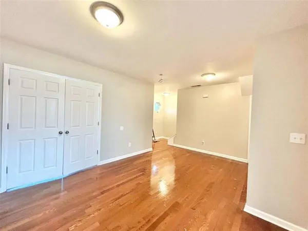 a view of an empty room with wooden floor