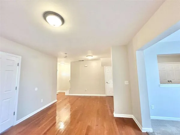 a view of an empty room with wooden floor