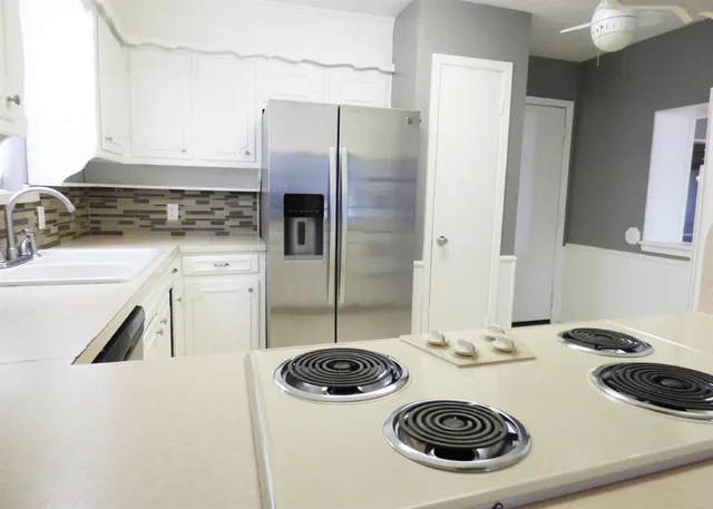 a kitchen with cabinets stainless steel appliances and sink