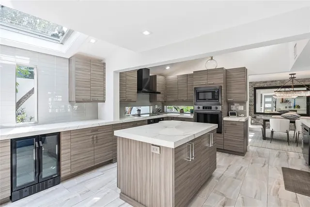 a large kitchen with stainless steel appliances a sink and cabinets
