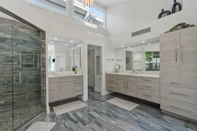 a bathroom with a granite countertop sink mirror and a shower