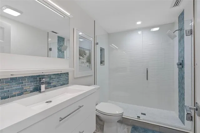 a bathroom with a sink a toilet and shower