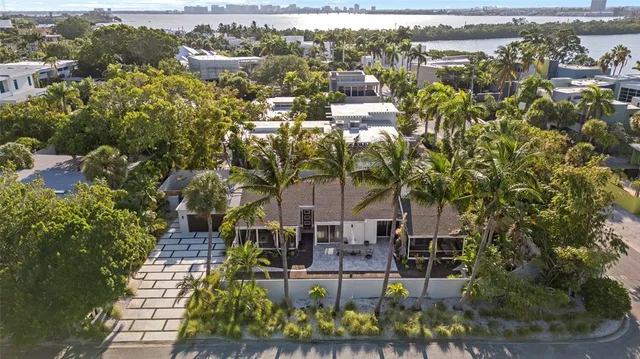 an aerial view of residential houses with outdoor space and trees