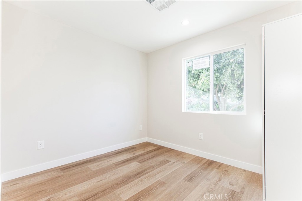 8879 Morehart Avenue Sun Valley, CA 91352 - Photo 11 of 13 an empty room with wooden floor and windows
