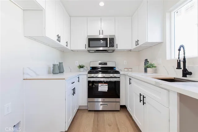 a kitchen with stainless steel appliances granite countertop a sink and a stove