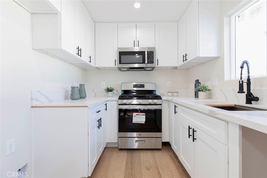8879 Morehart Avenue Sun Valley, CA 91352 - Photo 7 of 13 a kitchen with stainless steel appliances granite countertop a sink and a stove