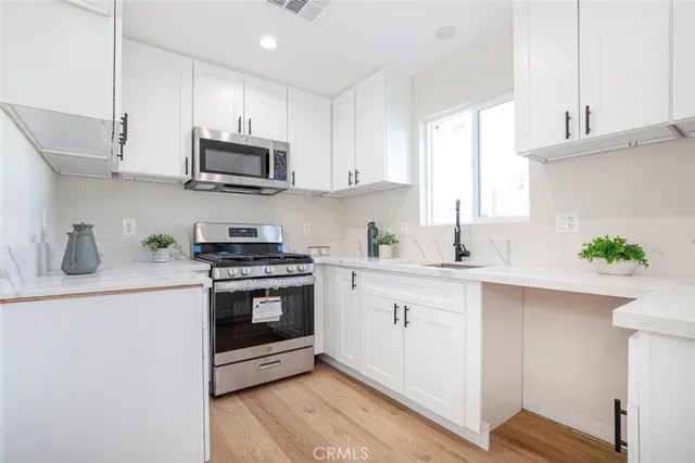a kitchen with stainless steel appliances granite countertop a sink a stove and cabinets