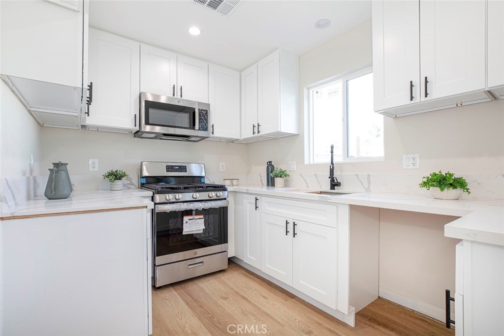 8879 Morehart Avenue Sun Valley, CA 91352 - Photo 8 of 13 a kitchen with stainless steel appliances granite countertop a sink a stove and cabinets