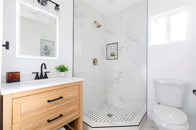 a bathroom with a sink a toilet and shower