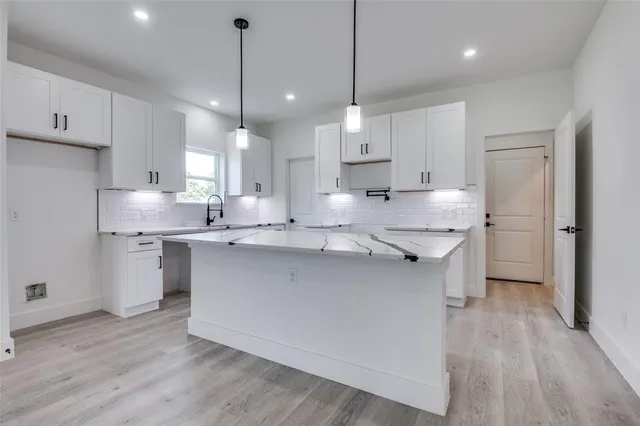 a kitchen with kitchen island a sink stainless steel appliances and cabinets