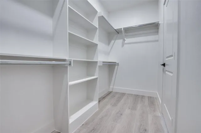 a view of walk in closet with empty racks