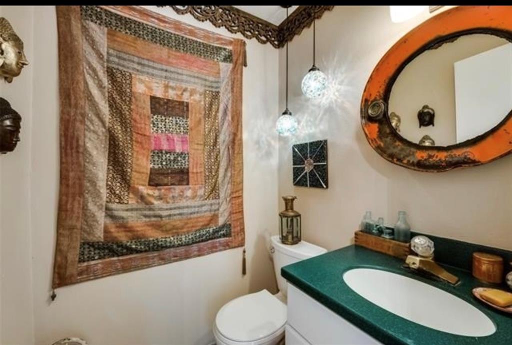 6049 West Red Bird Lane Dallas, TX 75236 - Photo 28 of 34 a bathroom with a toilet a sink and a mirror