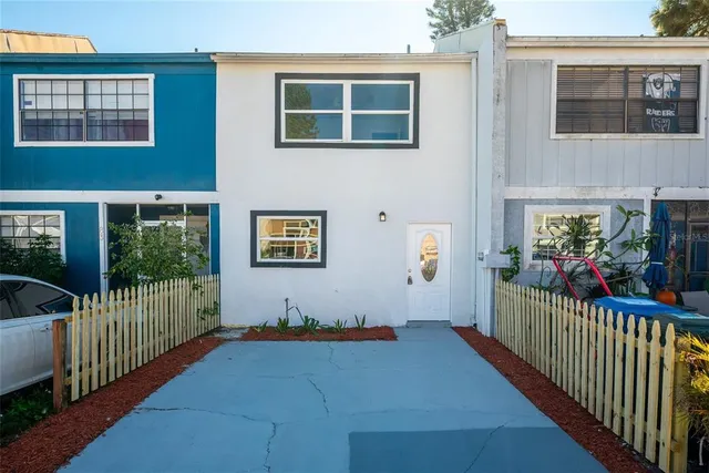 a view of a house with wooden deck and furniture