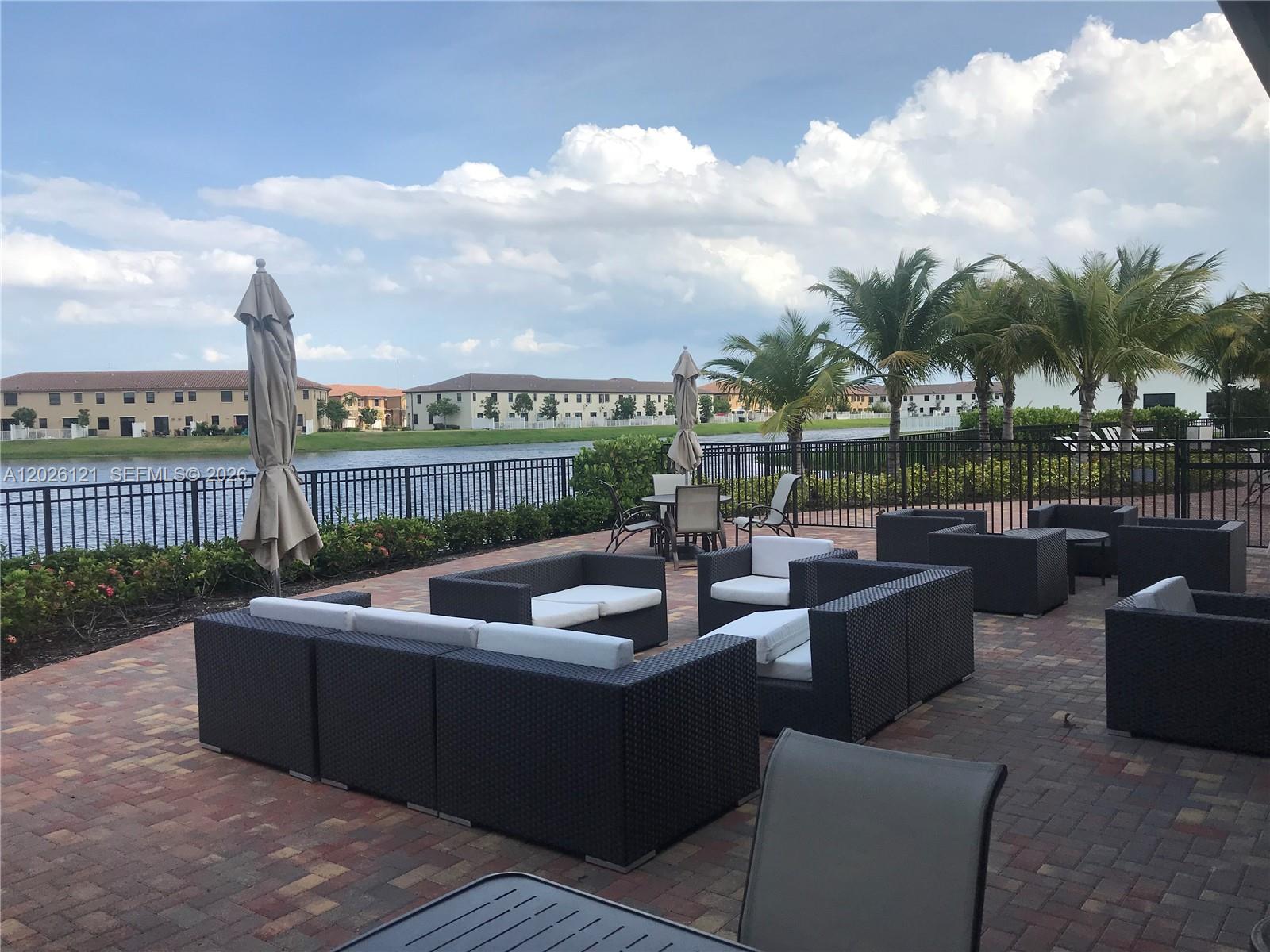 9307 West 33rd Way Hialeah, FL 33018 - Photo 21 of 23 a view of a patio with couches potted plants and city view