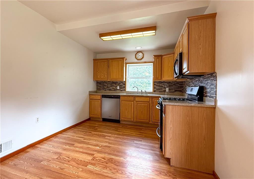 122 Lower Troy Hill Road Kittanning, PA 16201 - Photo 7 of 42 a kitchen with stainless steel appliances granite countertop a sink cabinets and wooden floor