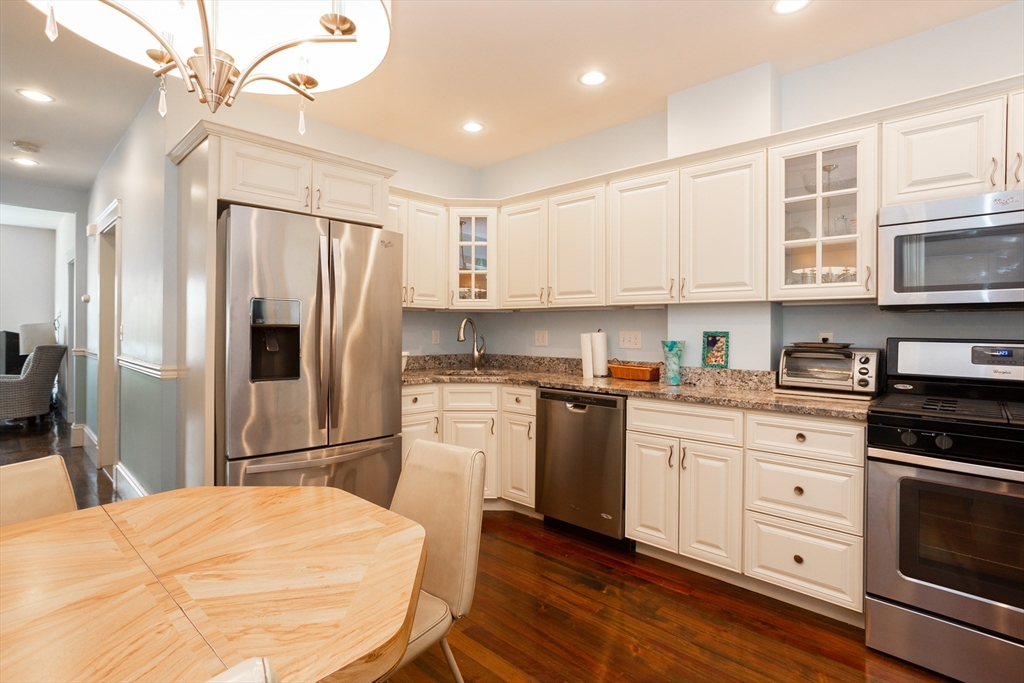 a kitchen with a refrigerator cabinets and wooden floor
