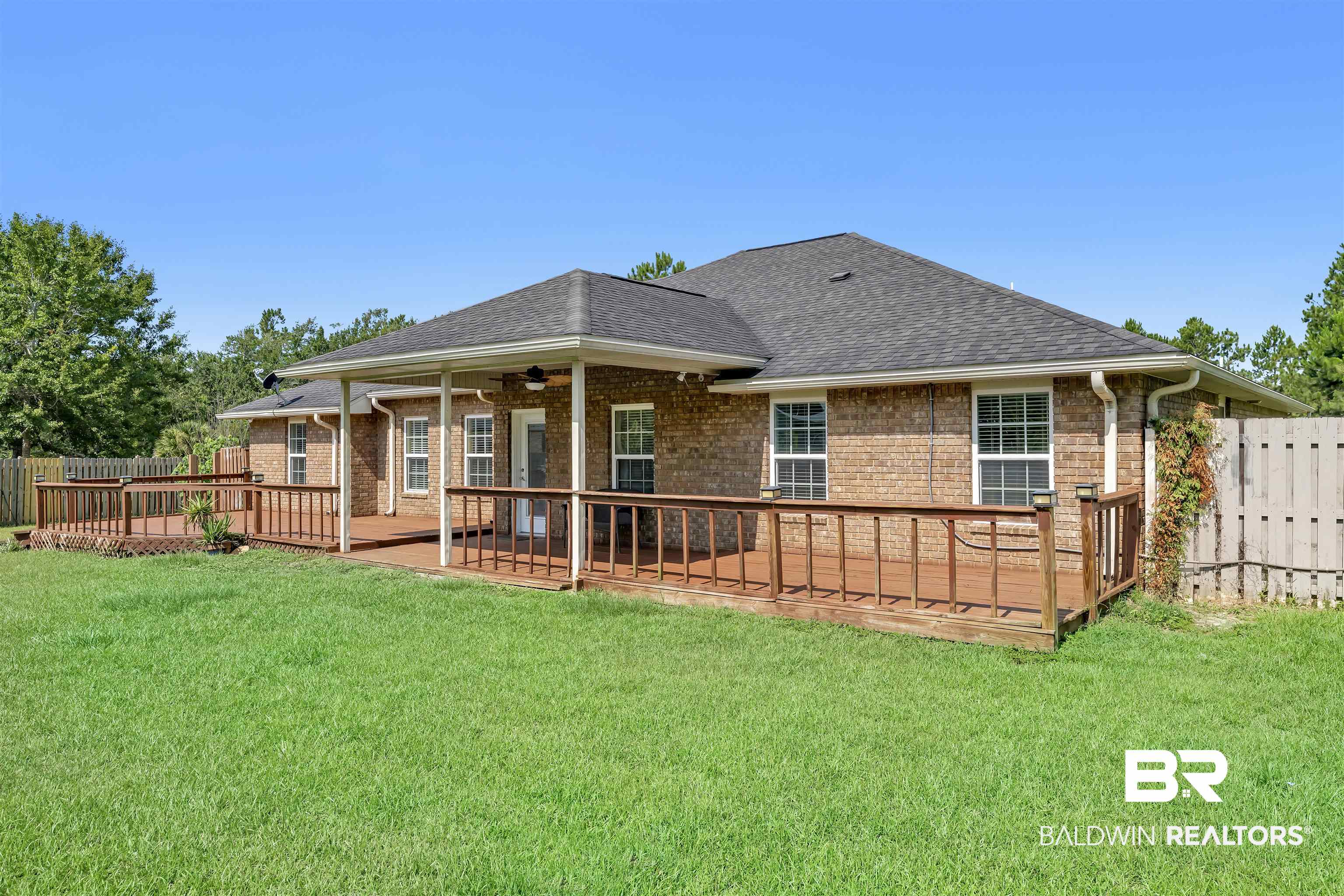10147 Lyttleton Loop Lillian, AL 36549 - Photo 6 of 29 Expansive backyard featuring a brick exterior, covered patio, extensive wood deck, and a privacy fence
